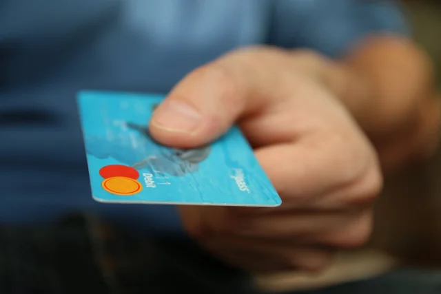 Tarjetas electrónicas y billetes representando el sistema pionero de beneficios sociales ABES implementado en 2004, adelantándose 20 años a soluciones modernas de pagos digitales.